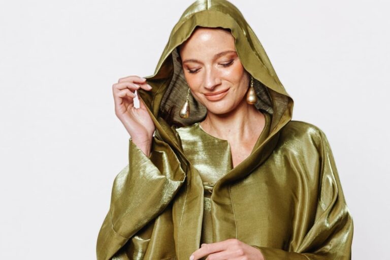 Modella con giacca iridescente oro oliva e cappuccio della collezione cerimonia Martino Midali