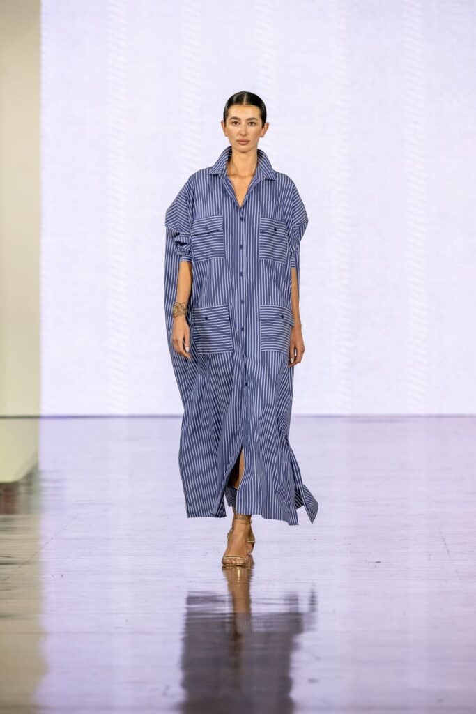 Chemisier lungo Martino Midali a righe blu e bianche, con bottoni frontali e quattro tasche a righe orizzontali.
