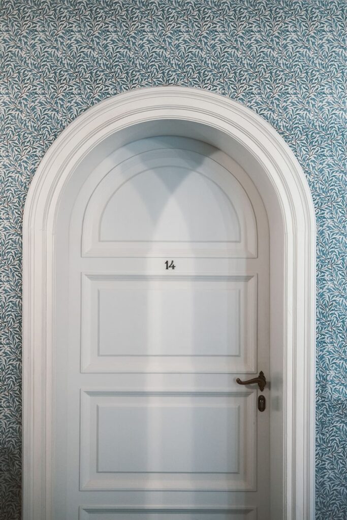 Porta bianca e carta da parati liberty negli interni di Villa Agnelli