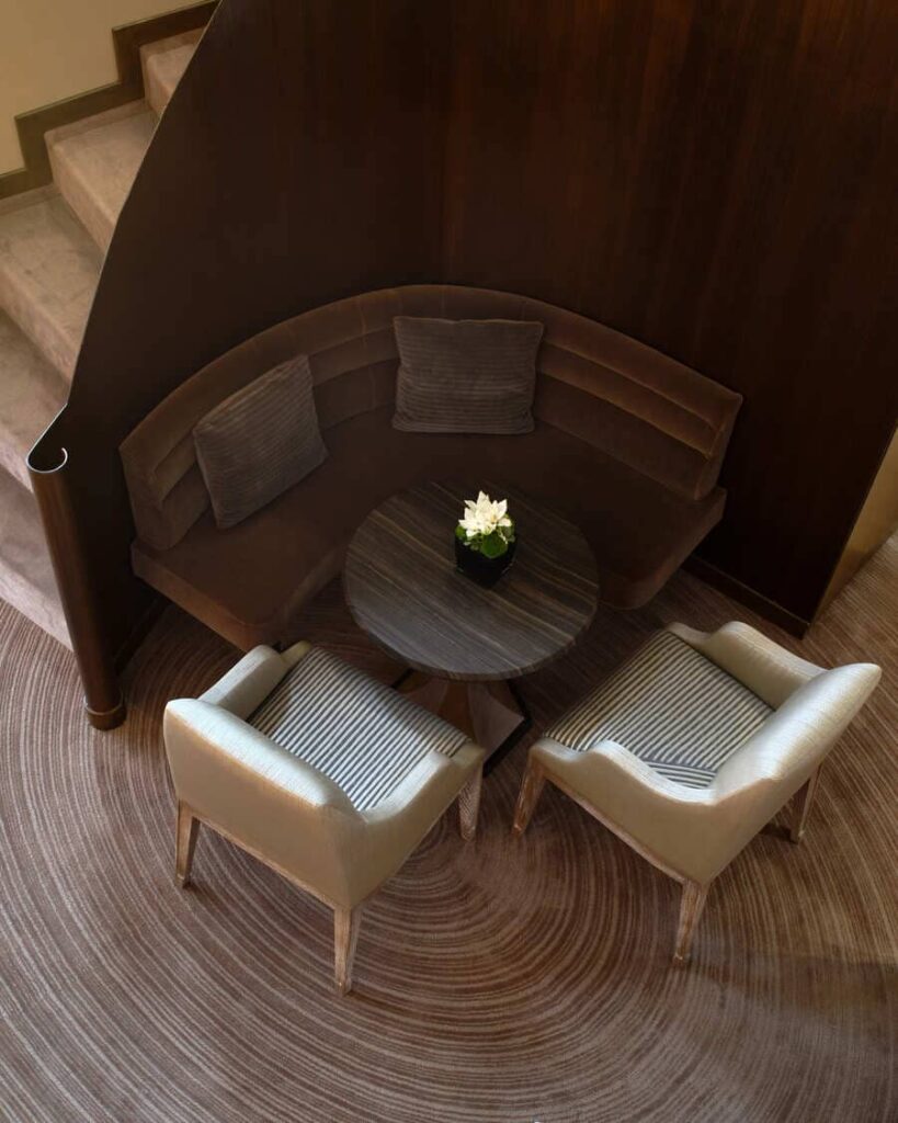 Angolo lounge del Caviar Bar Buccellati con sedute raccolte, tavolino e pareti in legno