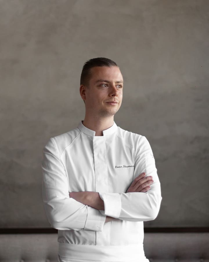 Lo chef Evan Neumann di Auro nella Napa Valley, ritratto in giacca bianca con le braccia incrociate.