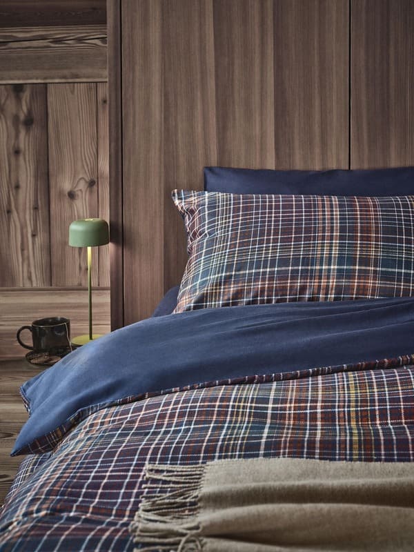 Dettaglio della biancheria da letto a quadri della collezione Coincasa Abitare la natura