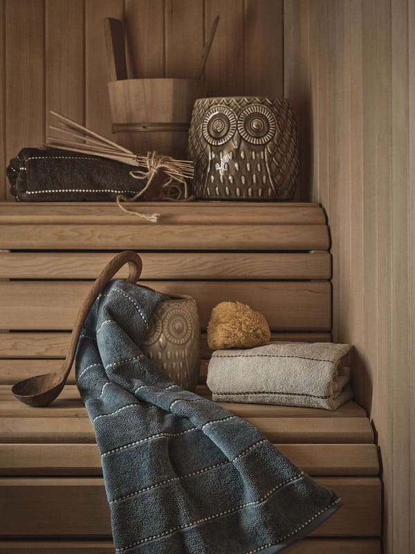 Accessori bagno della collezione Coincasa Abitare la natura, tra spugne e oggetti in ceramica, in un ambiente in legno