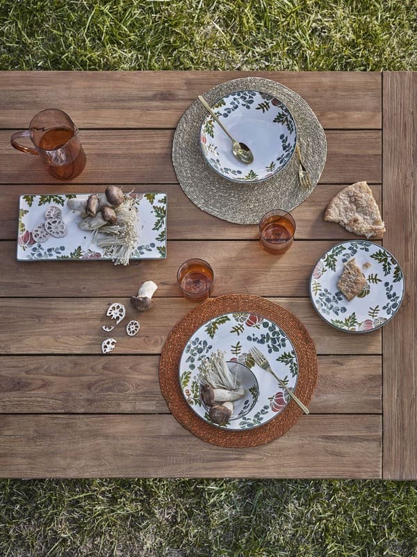 Mise en place della collezione Coincasa Abitare la natura con piatti in ceramica a motivo botanico e accessori da tavola
