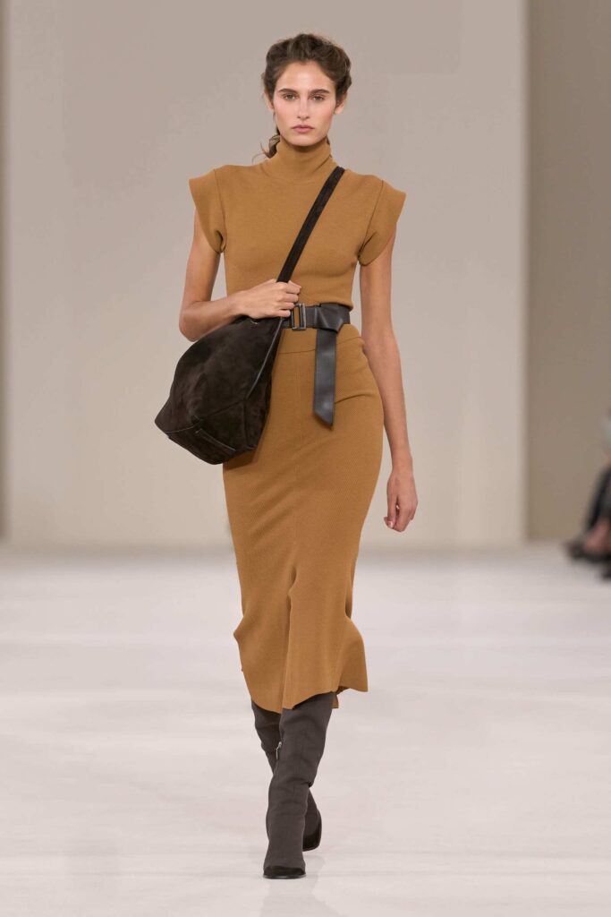 Look Max Mara PE 2027 con abito in maglia nei toni naturali, cintura nera e borsa a tracolla
