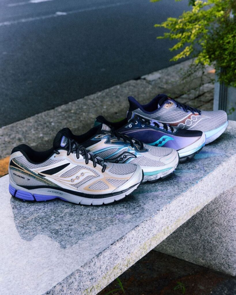 Quattro scarpe della capsule Saucony Daikanyama allineate su una panchina in pietra, tra mesh chiaro e tonalità viola.