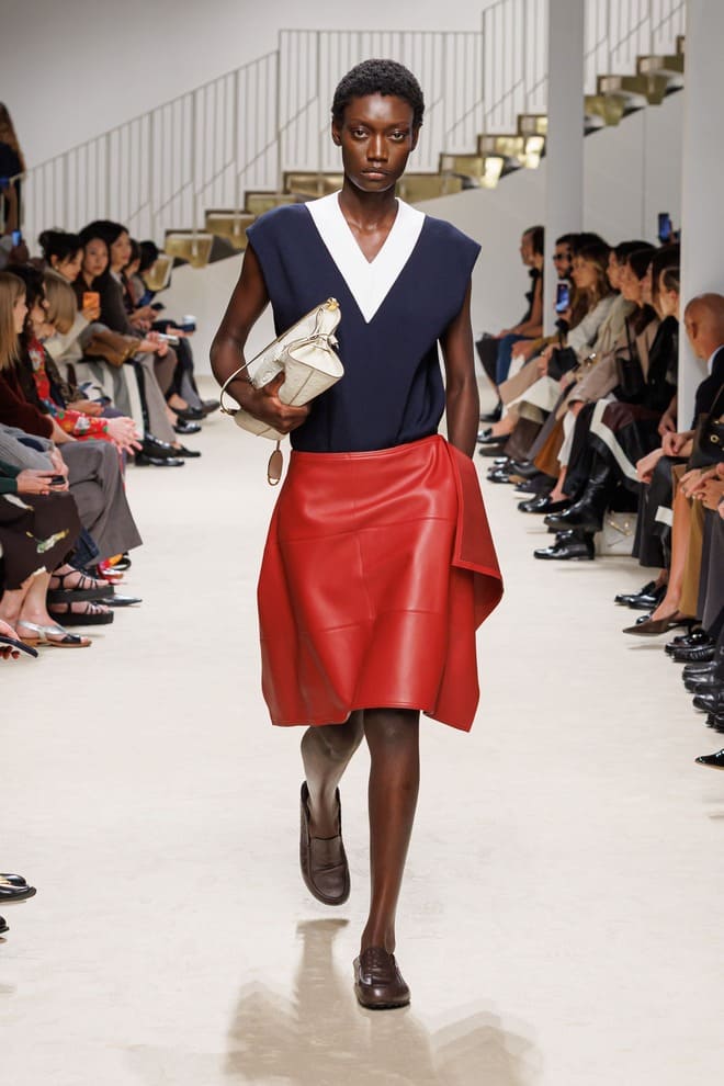 Look Tod's donna PE 2027 con maglia blu, gonna rossa in pelle e borsa chiara