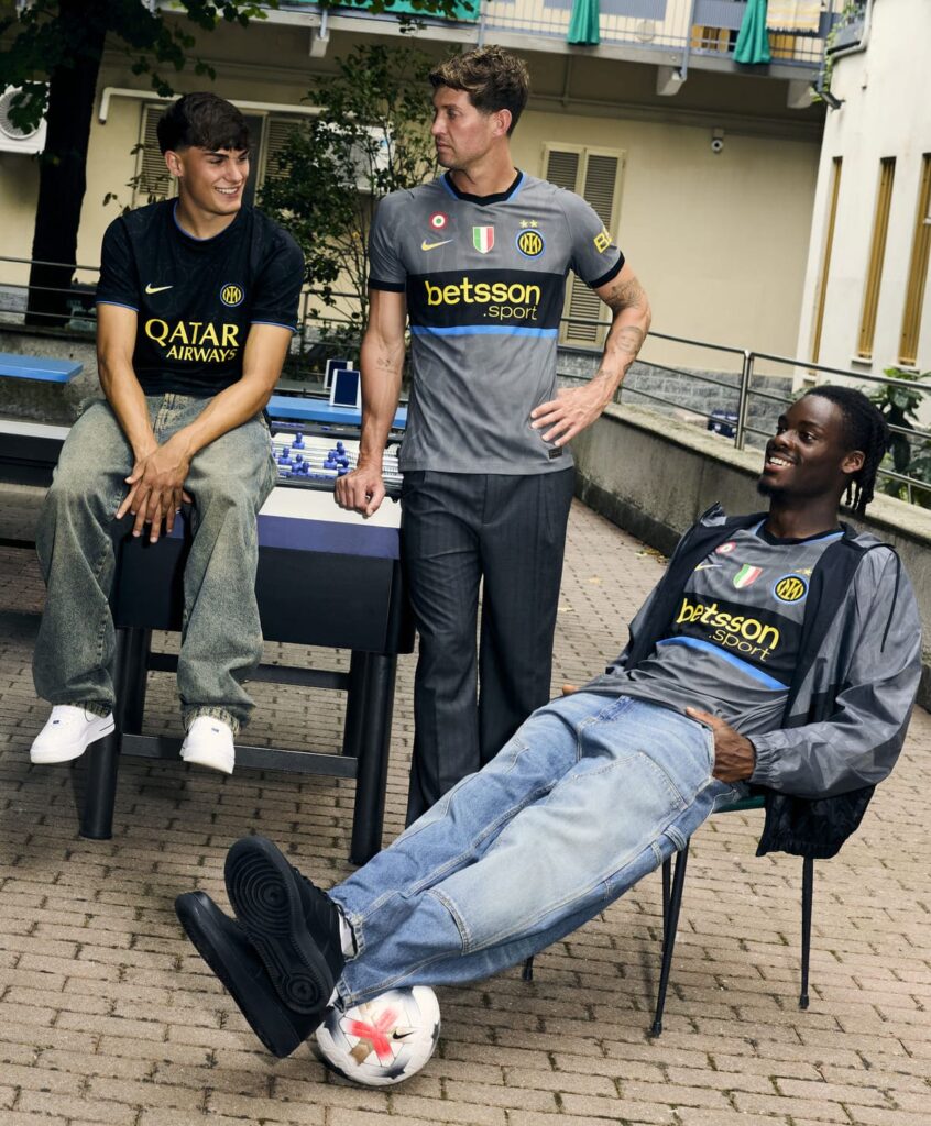 John Stones, Yann-Aurel Bisseck e Mattia Mosconi fotografati in un cortile milanese per la campagna della nuova terza maglia Inter