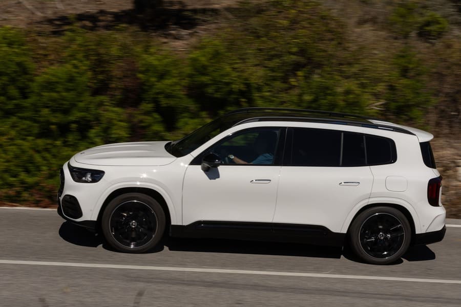 Mercedes GLB bianca ripresa di lato su strada, con tetto e cerchi scuri.